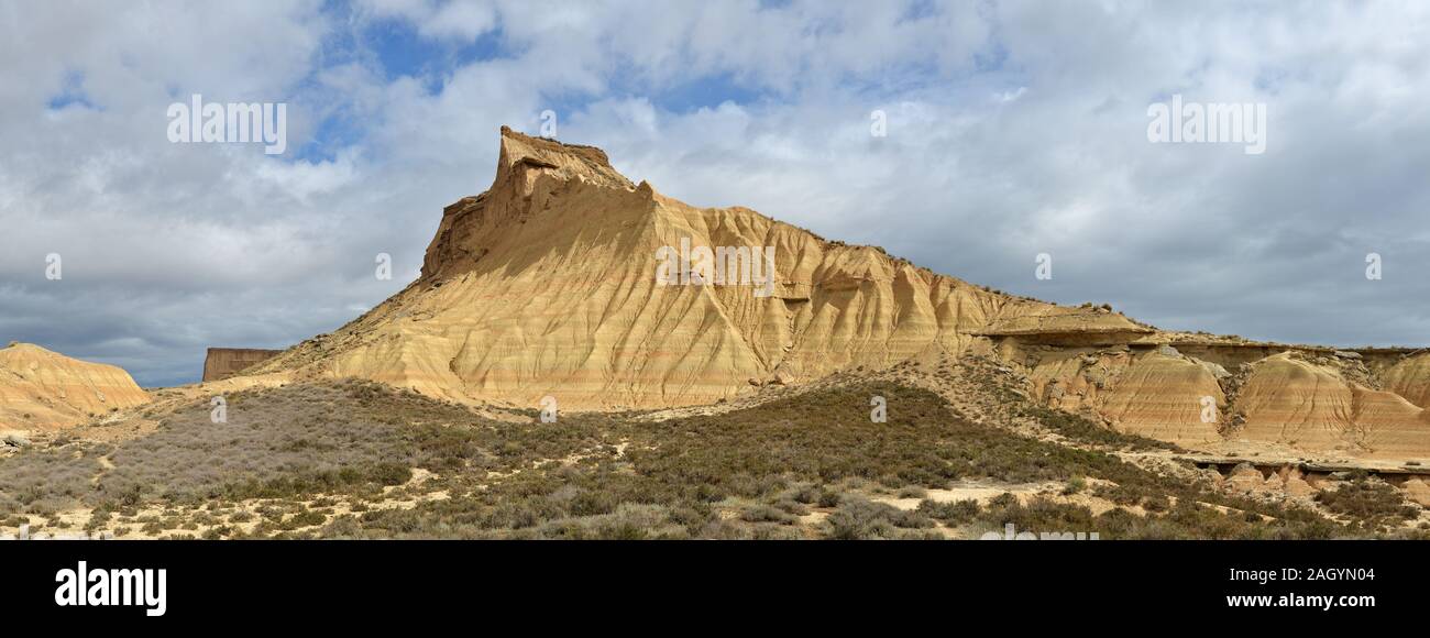 Stratified mountain with a shrubby foothill in the badlands Bardenas Reales Stock Photo