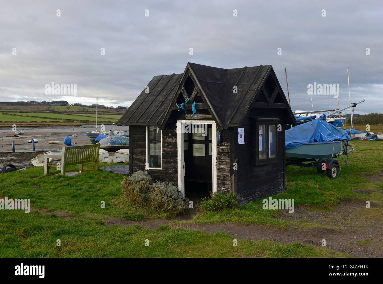 Hut of the River Aln boating club with boats beached at low tide at the mouth of the river Aln in Alnmouth, Northumberland, UK Stock Photo