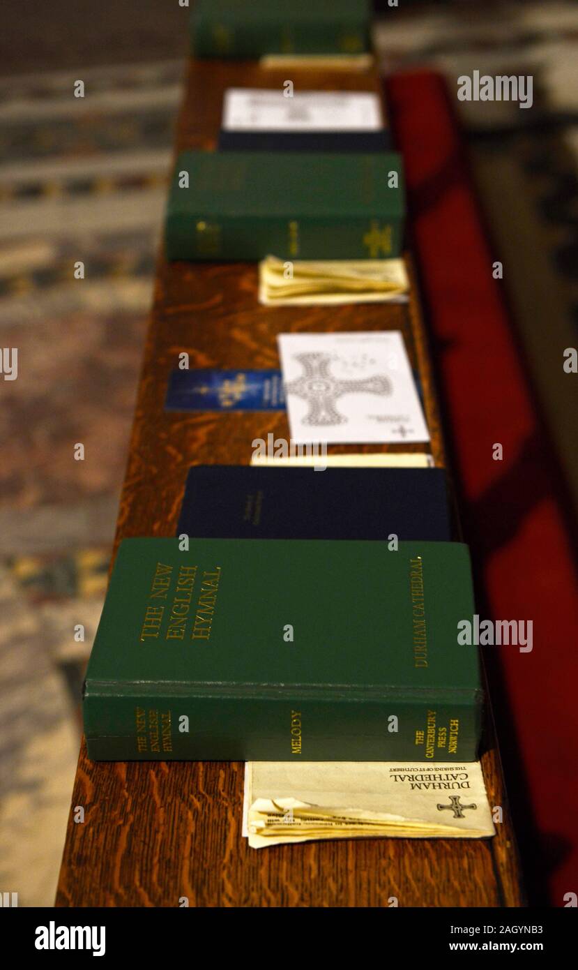 Copies of the Anglican New English Hymnal hymn book placed out and ready for use by worshipers at Durham cathedral, UK Stock Photo