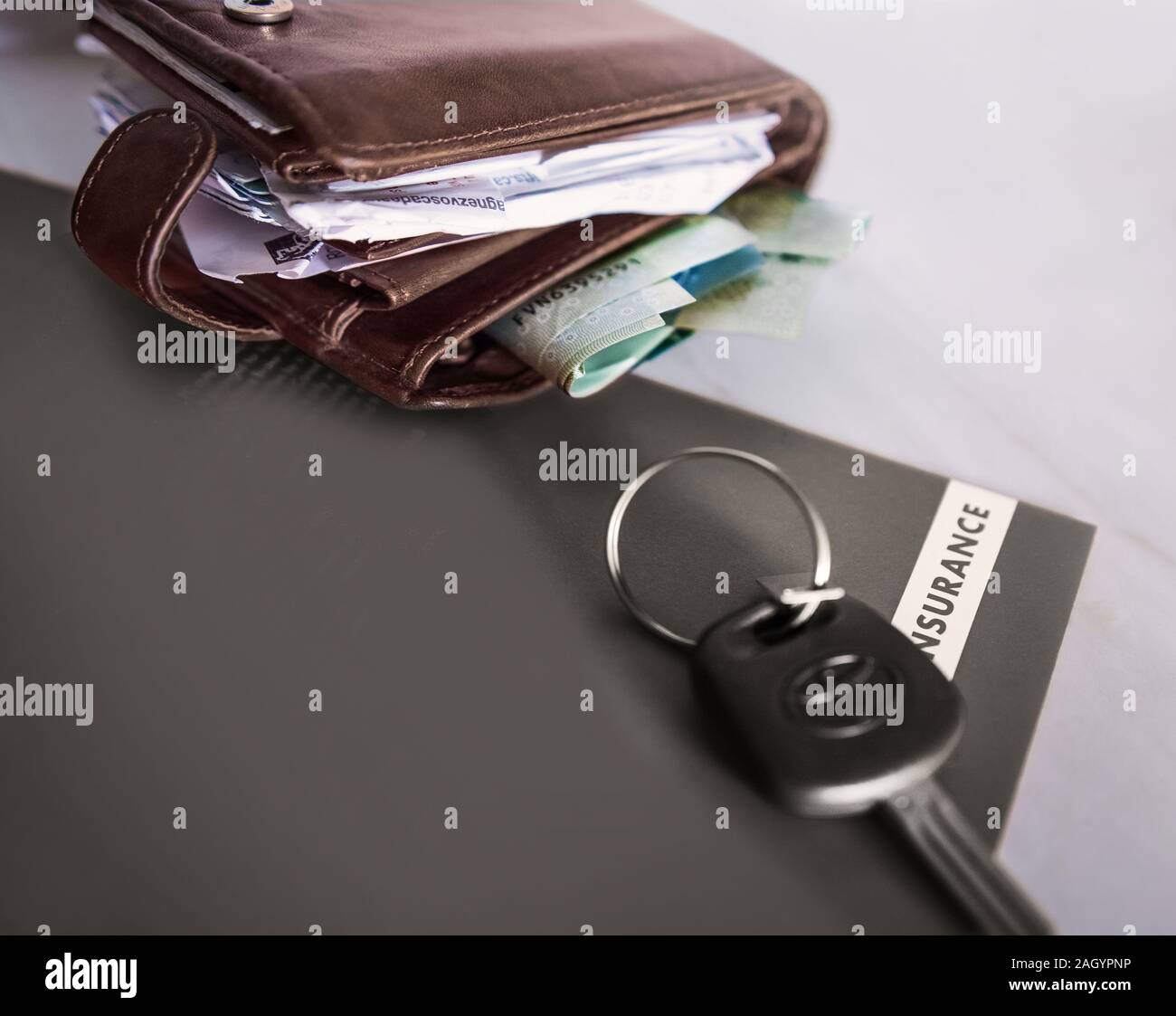 Wallet Insurance A wallet full of money and probably bills and the car key next to it ...