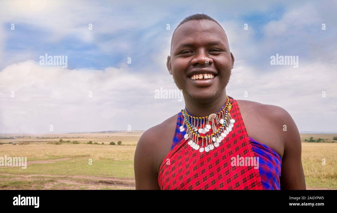 An adult male member of the Masai tribe in Kenya, wearing the traditional tribal jewelry and red colored clothing of the Masai. Stock Photo