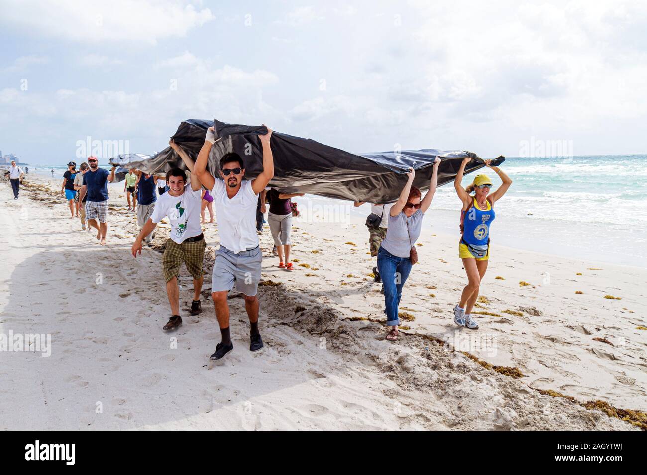 Miami Beach Florida,oil spill protest,offshore drilling,Black plastic sheet represents slick,Atlantic Ocean,water,Hispanic man men male,FL100515040 Stock Photo