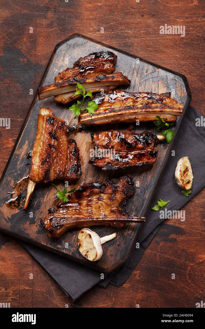 Barbecue beef ribs with bbq sauce sliced on a wooden board. Top view flat lay Stock Photo