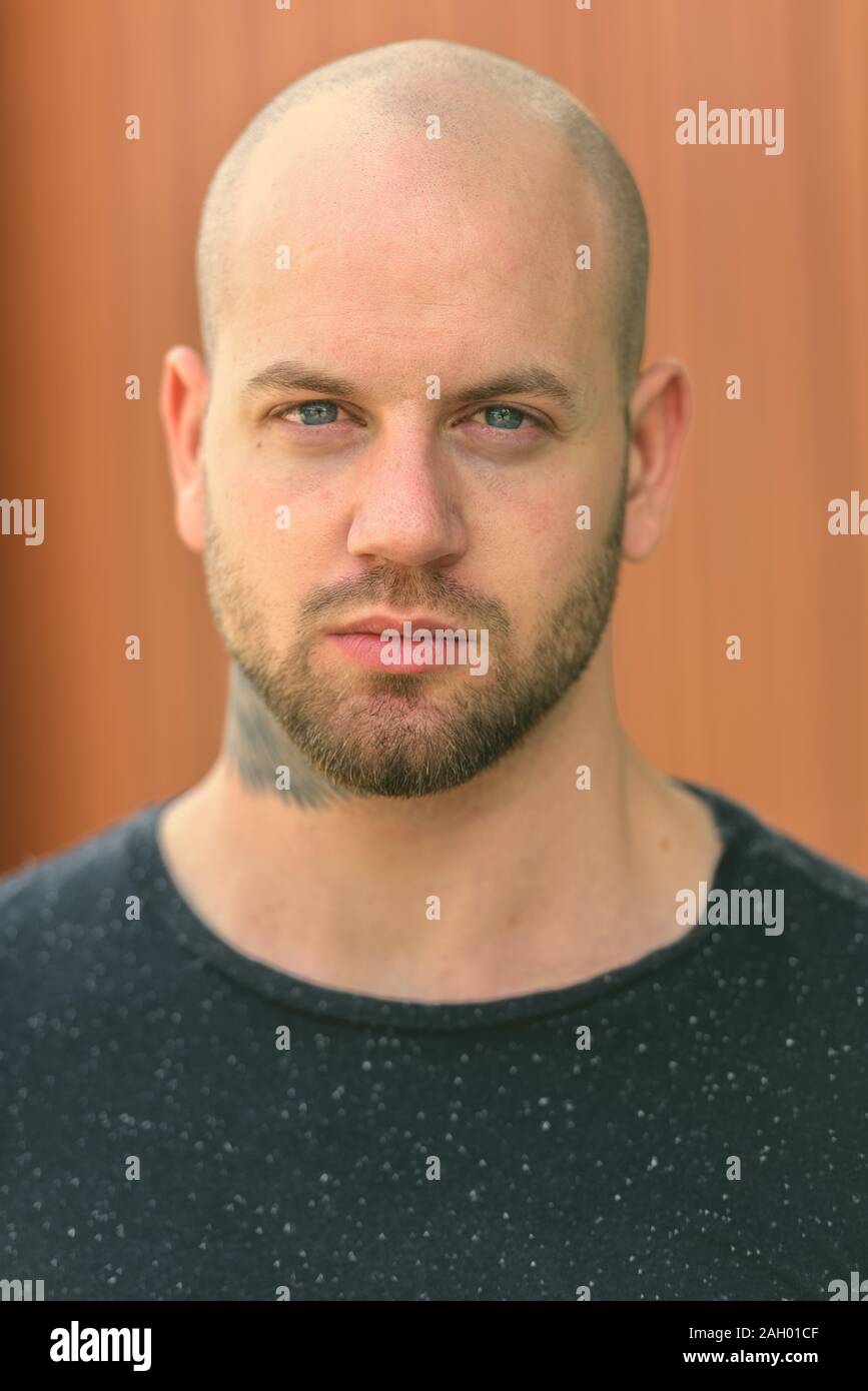 Face of young bald muscular man with tattoos outdoors Stock Photo - Alamy