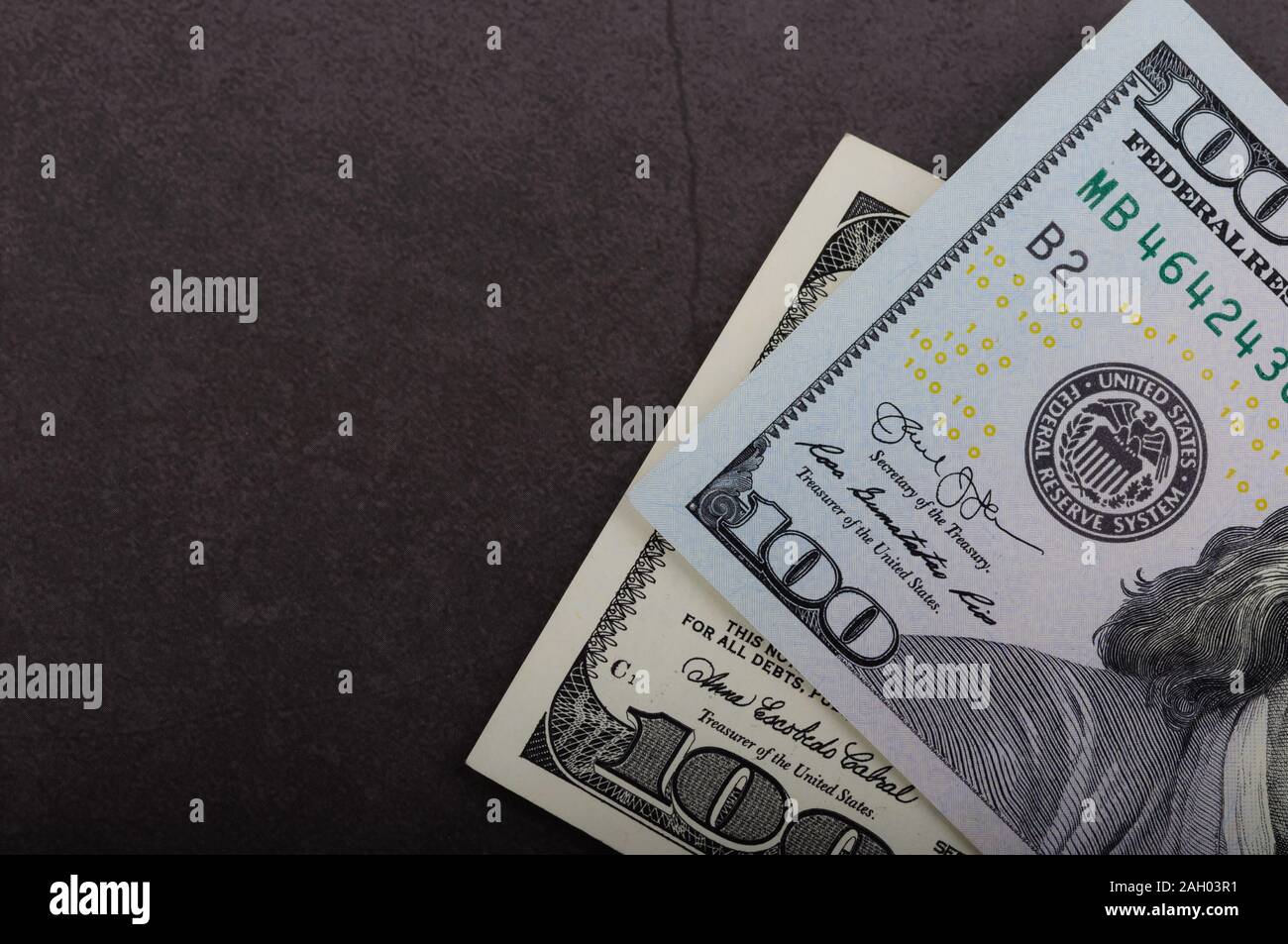One hundred dollar bills on a gray background Stock Photo - Alamy