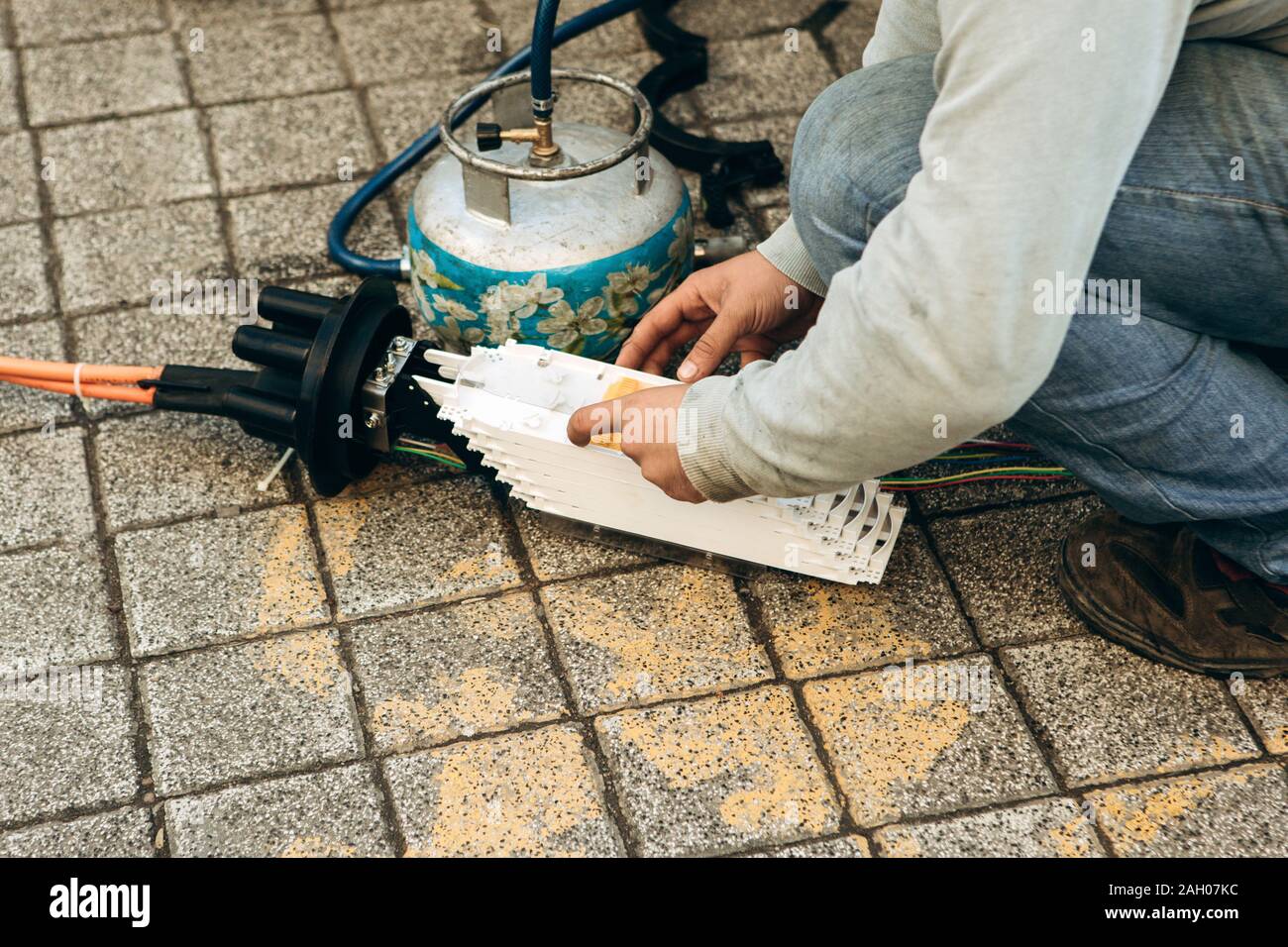 A plumber or utility worker repairs a broken water pump on the street. The work of municipal utilities. Stock Photo