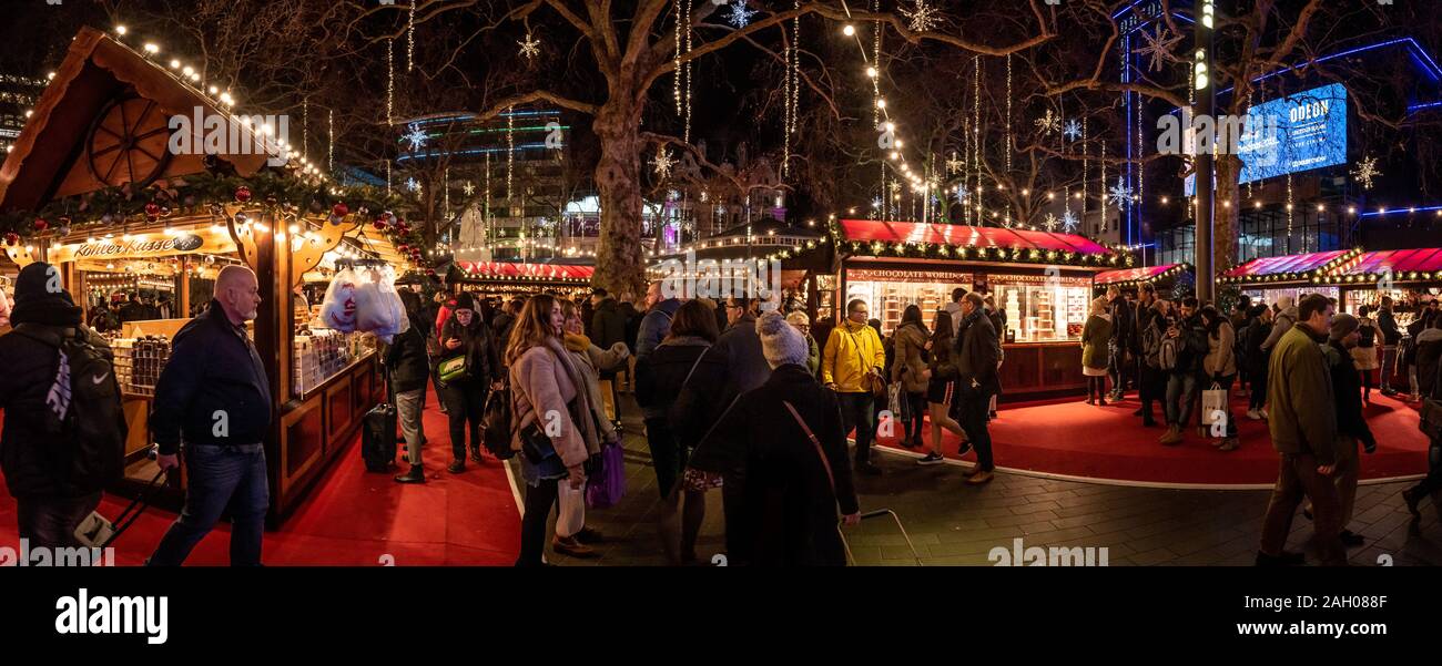 LONDON, ENGLAND, DECEMBER 10th, 2018: People having fun in a nicely illuminated christmas fair while walking around, shopping and drinking hot Stock Photo