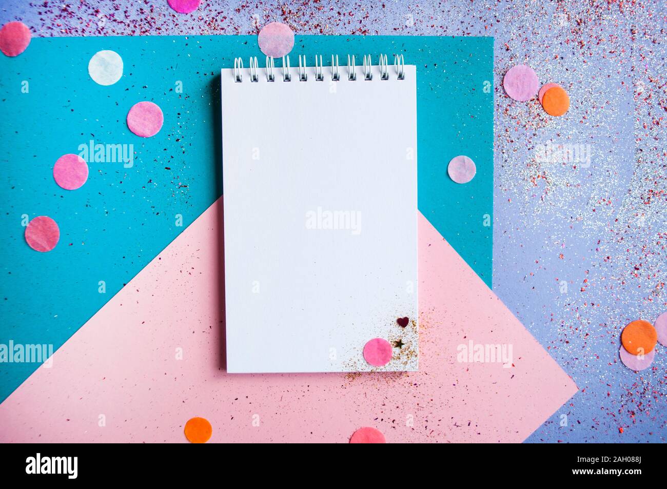 Colorful confetti, sparkles and notebook with wish list on bright