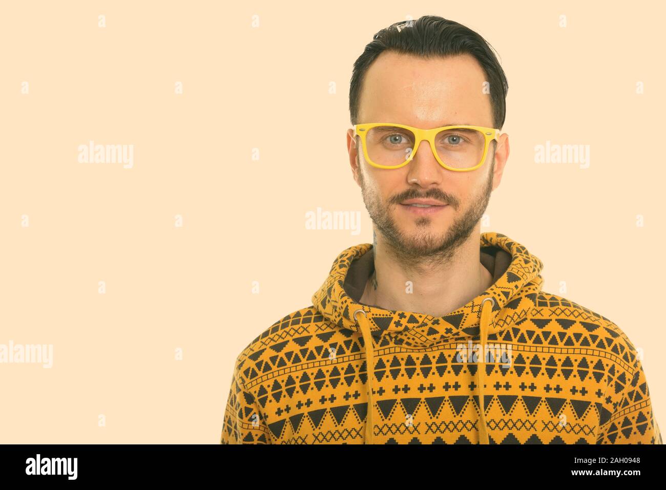 Studio shot of young man wearing yellow eyeglasses Stock Photo