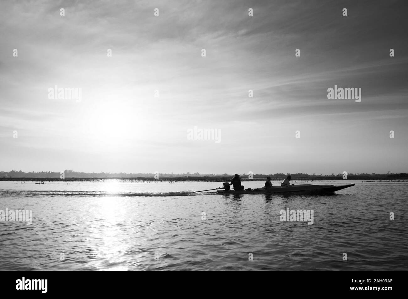 JAN 13, 2019 Udonthani, Thailand - Thai long tail boat with tourist in peaceful Nong Harn lake, Udonthani - Thailand. Wooden boat under warm sunrise Stock Photo
