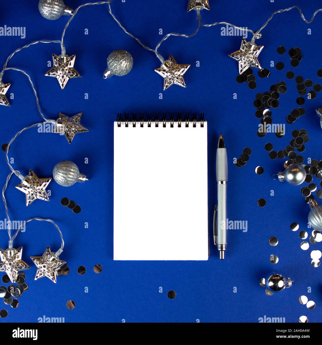 Christmas, winter composition. Notebook with isolated white page, open diary, sketch book mock-up scene on blue surface. Stock Photo