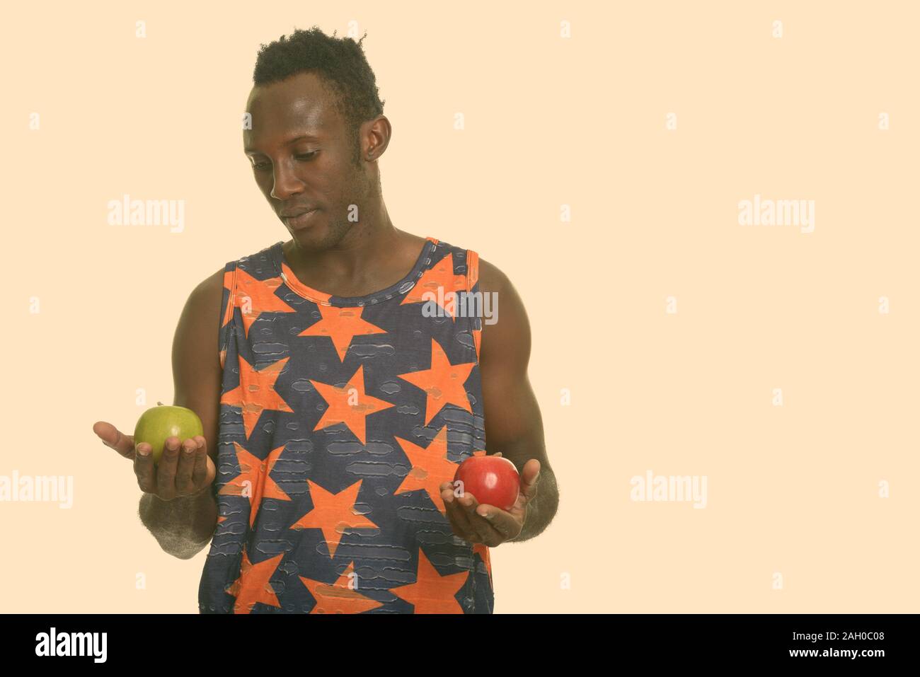 Young black African man choosing between green and red apple Stock ...