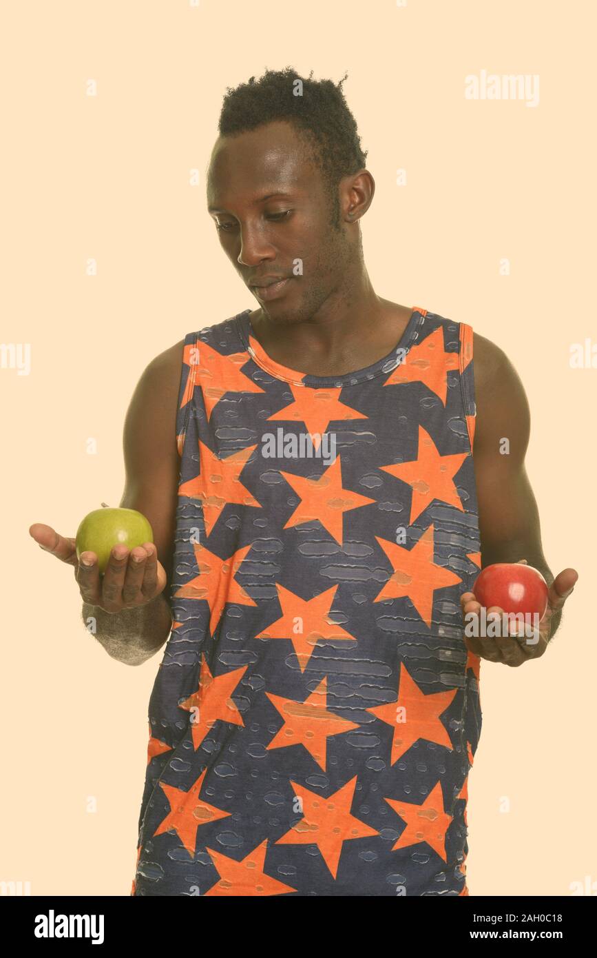 Young black African man choosing between green and red apple Stock ...