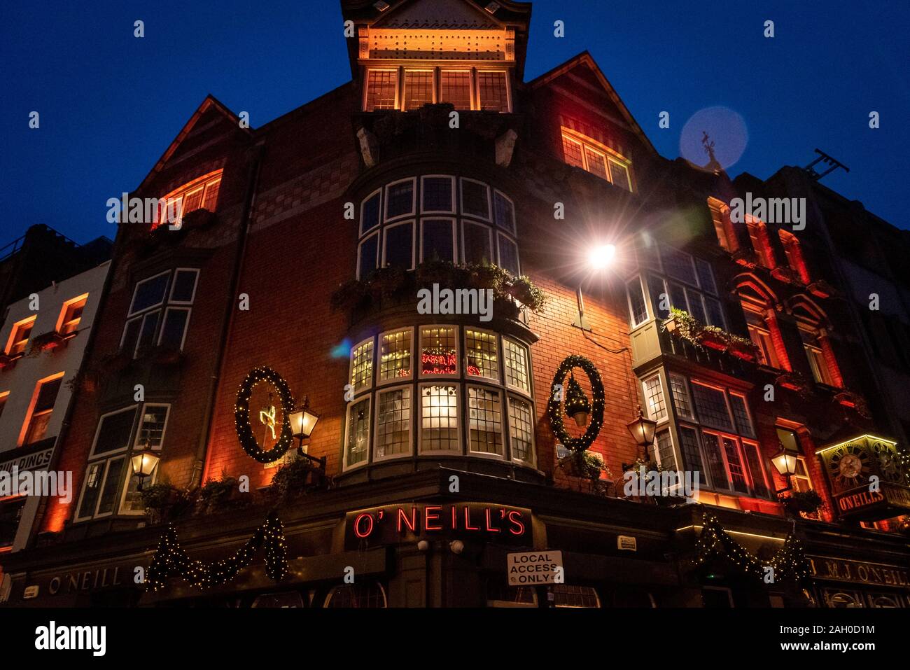 DUBLIN, IRELAND, DECEMBER 24, 2018: View of the exterior of the O'Neill's Pub and Kitchen on Suffolk Street, dimly lit and decorated for christmas Stock Photo