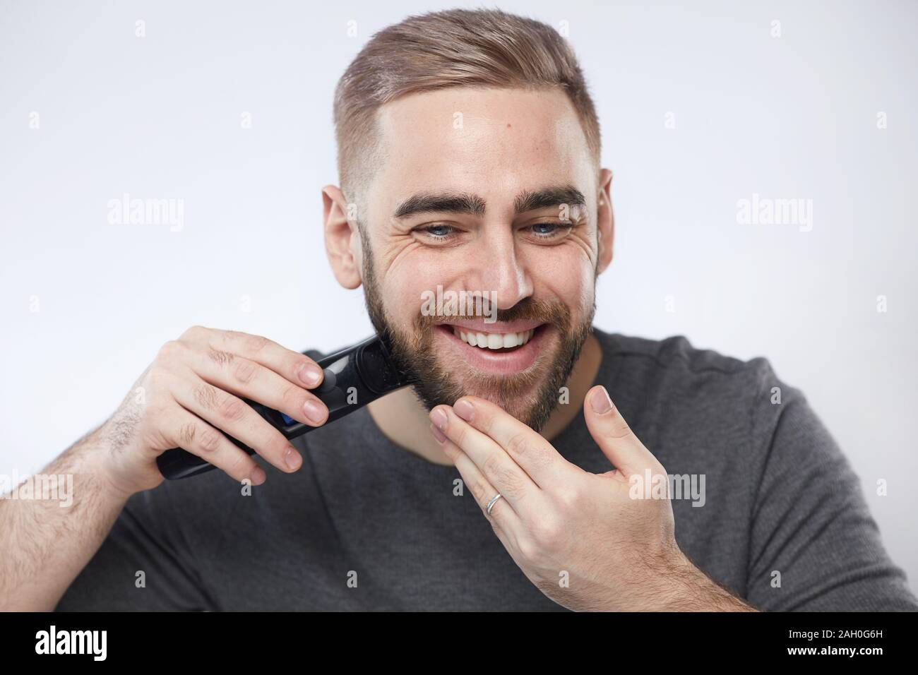Head and shoulders studio portrait shot of handsome young man smiling