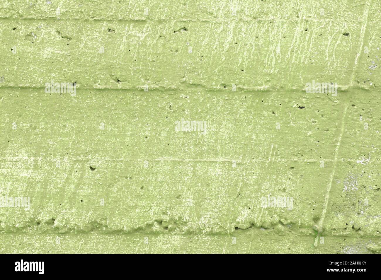 Green grunge wall texture. Rough grungy background. Caper green shade. Stock Photo