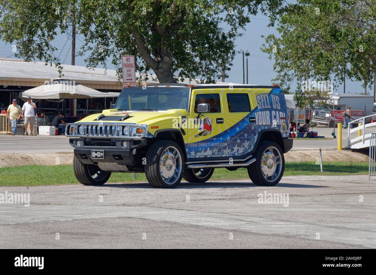 A Hummer H2 SUV with Texas Direct Auto advertising color scheme painted on it parked in a lot at the entrance into the Event. Stock Photo