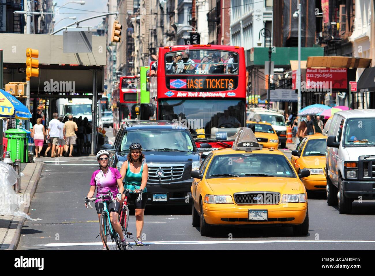NEW YORK, USA - JULY 5, 2013: Cyclists ride along Broadway in SoHo district, New York. Almost 19 million people live in New York City metropolitan are Stock Photo