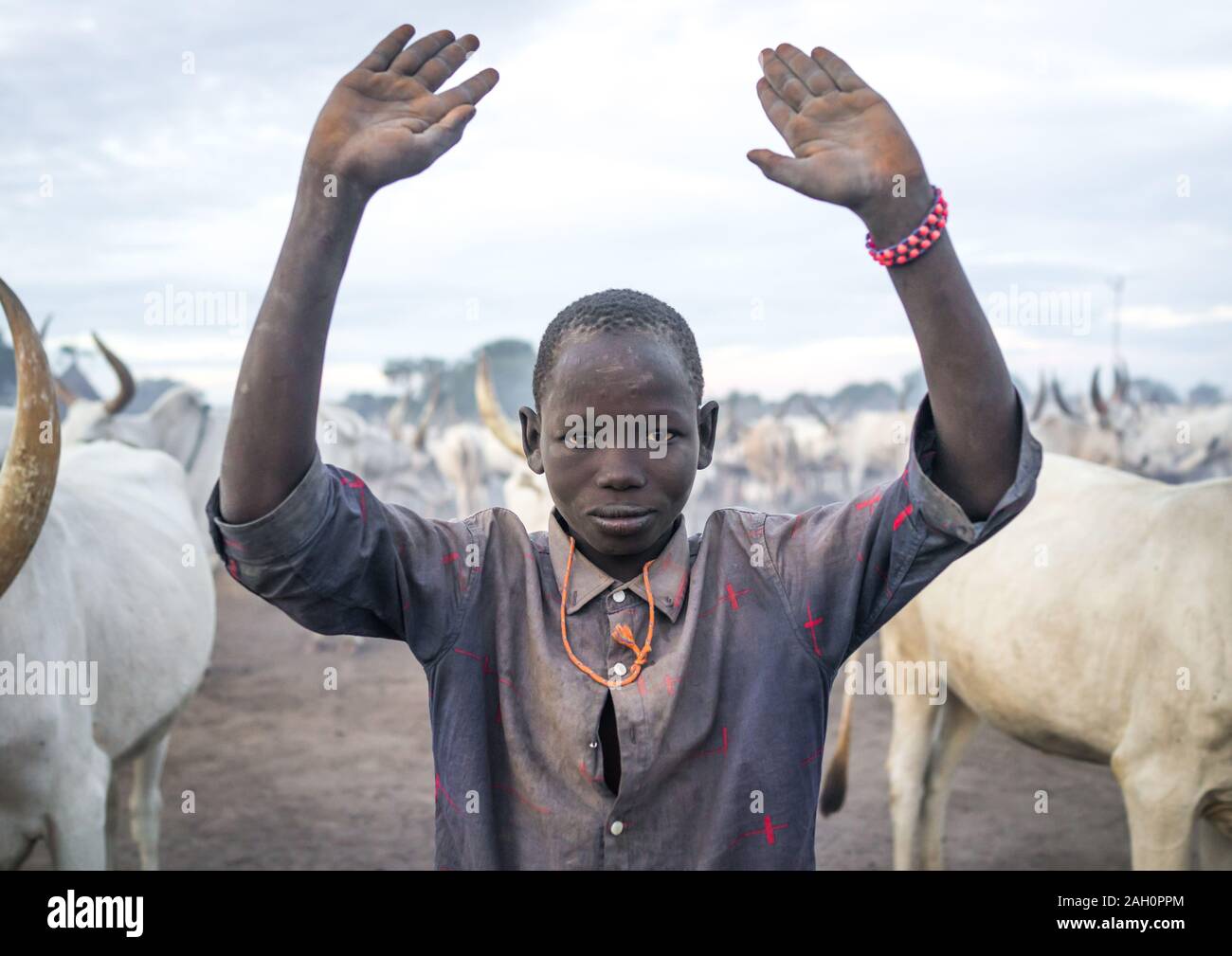 A Mundari tribe boy mimics the position of horns of his favourite cow, Central Equatoria, Terekeka, South Sudan Stock Photo