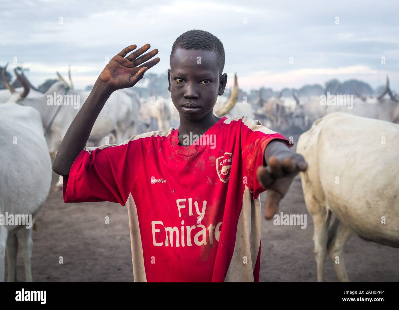 A Mundari tribe boy mimics the position of horns of his favourite cow, Central Equatoria, Terekeka, South Sudan Stock Photo