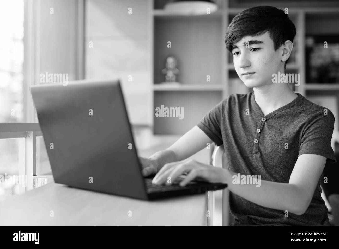Young handsome Iranian teenage boy relaxing at home Stock Photo