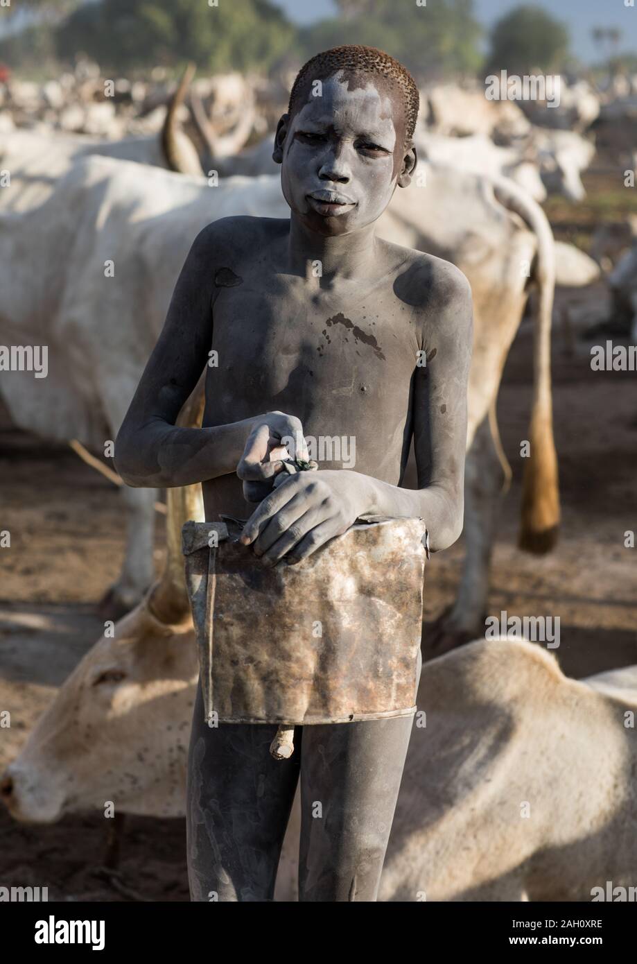 Mundari tribe boy with a bell taking care of the cows in the camp, Central Equatoria, Terekeka, South Sudan Stock Photo