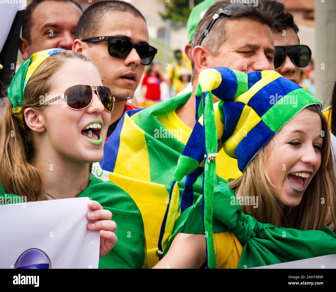 FORTALEZA, BRAZIL - 4 JULY 2014: A candid view of a pair of young female Brazilian soccer fans in their team colours and an excited mood before a matc Stock Photo