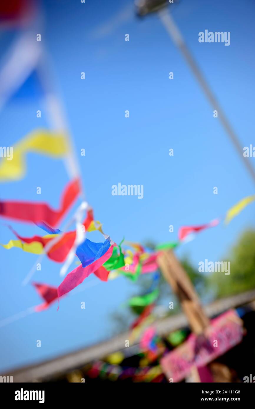 Bunting flutters in the wind against a bright blue sky. Stock Photo