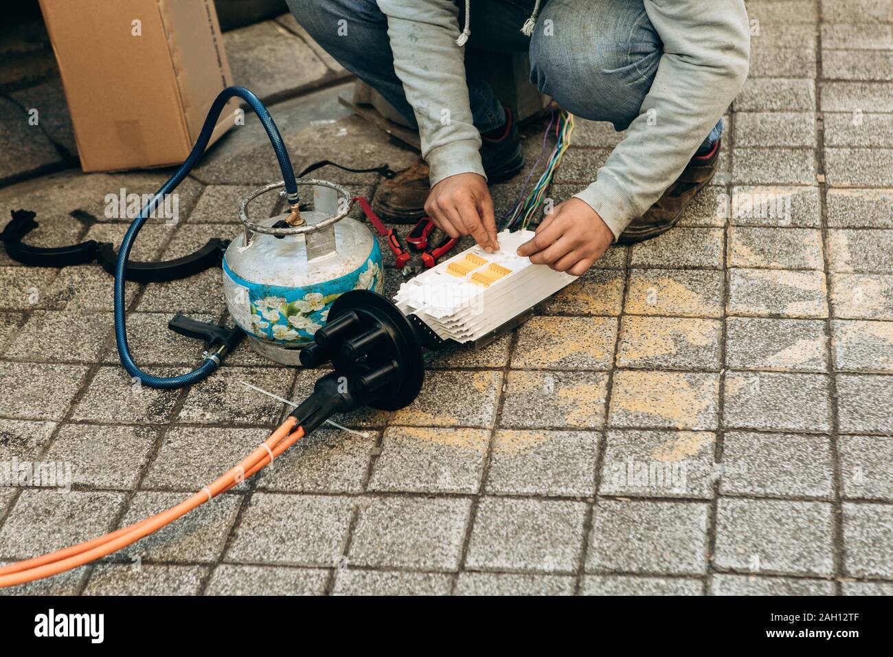 A plumber or utility worker repairs a broken water pump on the street. The work of municipal utilities. Stock Photo