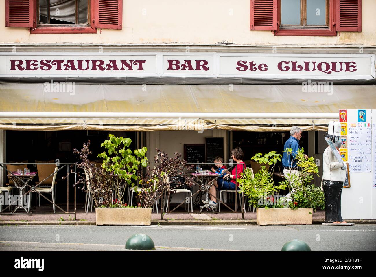 people sitting on the terrace in front of a small bar in southern france Stock Photo