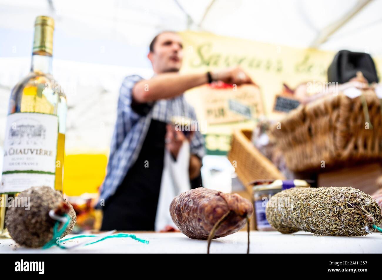 vendor selling local produce on a market in the sun in southern france Stock Photo