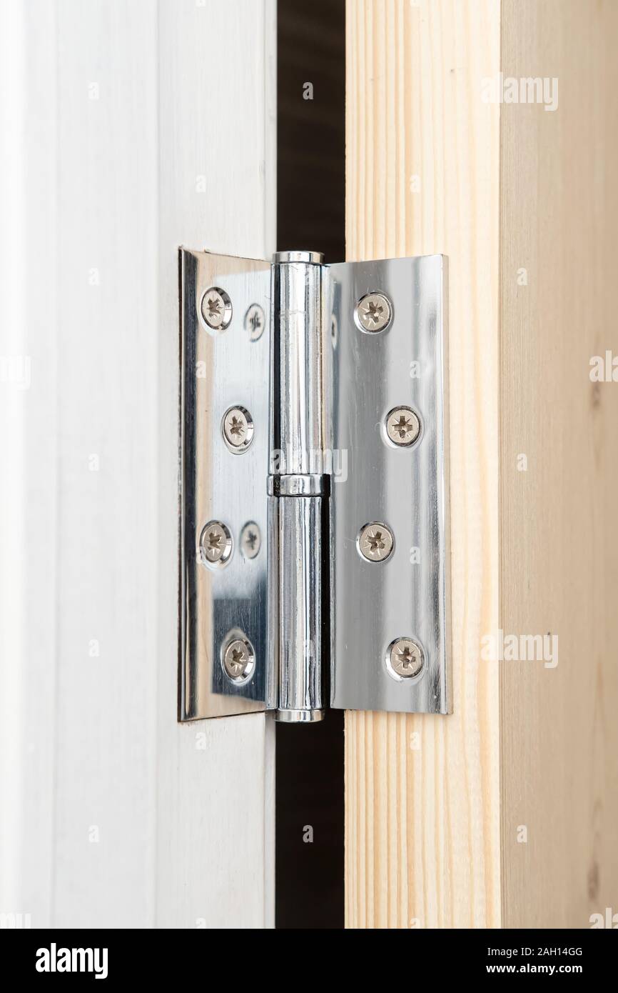 Shiny Metal Hinge On The Wooden Door Part Of Which Is Painted
