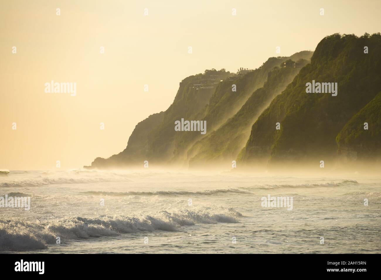 (Selective focus) Stunning view of the Melasti Beach with its cliff bathed by a rough sea during a beautiful sunset, South Bali, Indonesia. Stock Photo