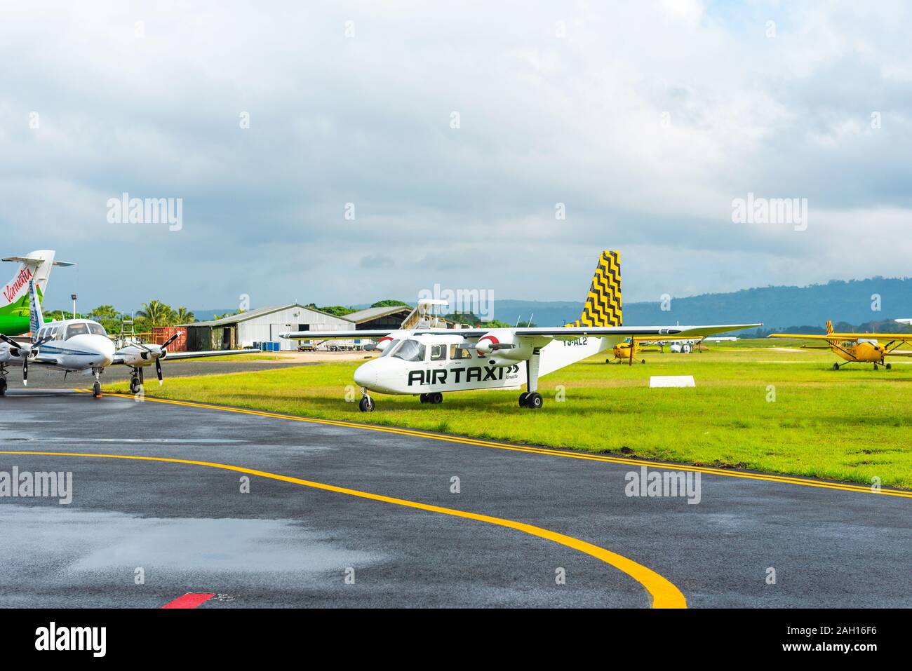 PORTVILA, VANUATU - JULY 19, 2019: Airplanes at the airport against the backdrop of a mountain landscape. Copy space for text Stock Photo