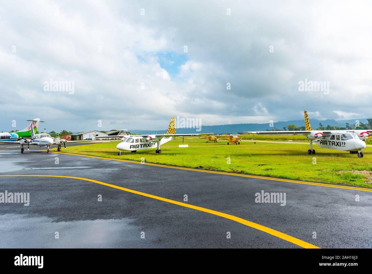 PORTVILA, VANUATU - JULY 19, 2019: Airplanes at the airport against the backdrop of a mountain landscape. Copy space for text Stock Photo