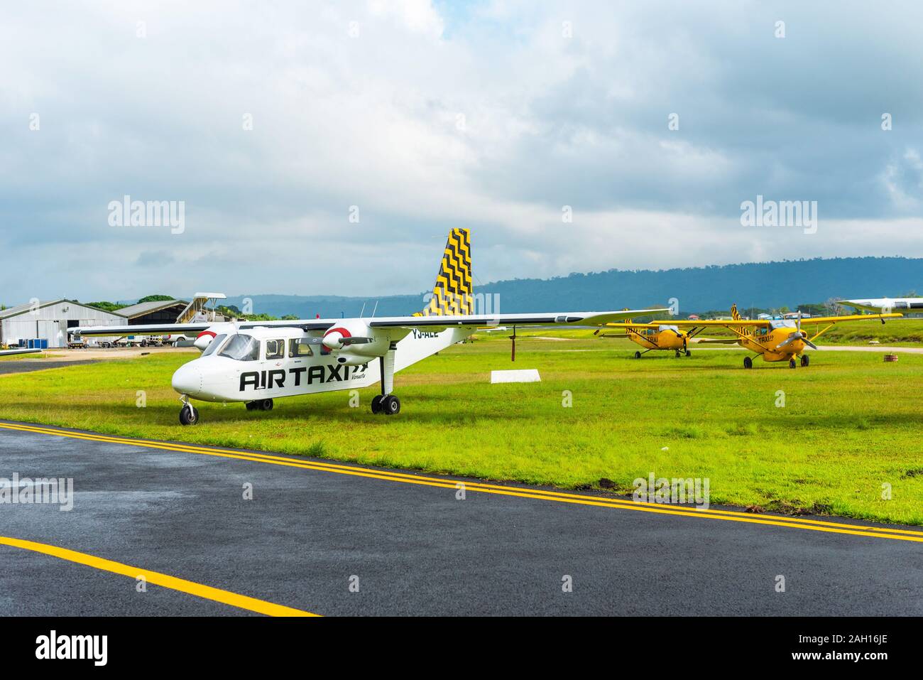 PORTVILA, VANUATU - JULY 19, 2019: Airplanes at the airport against the backdrop of a mountain landscape. Copy space for text Stock Photo
