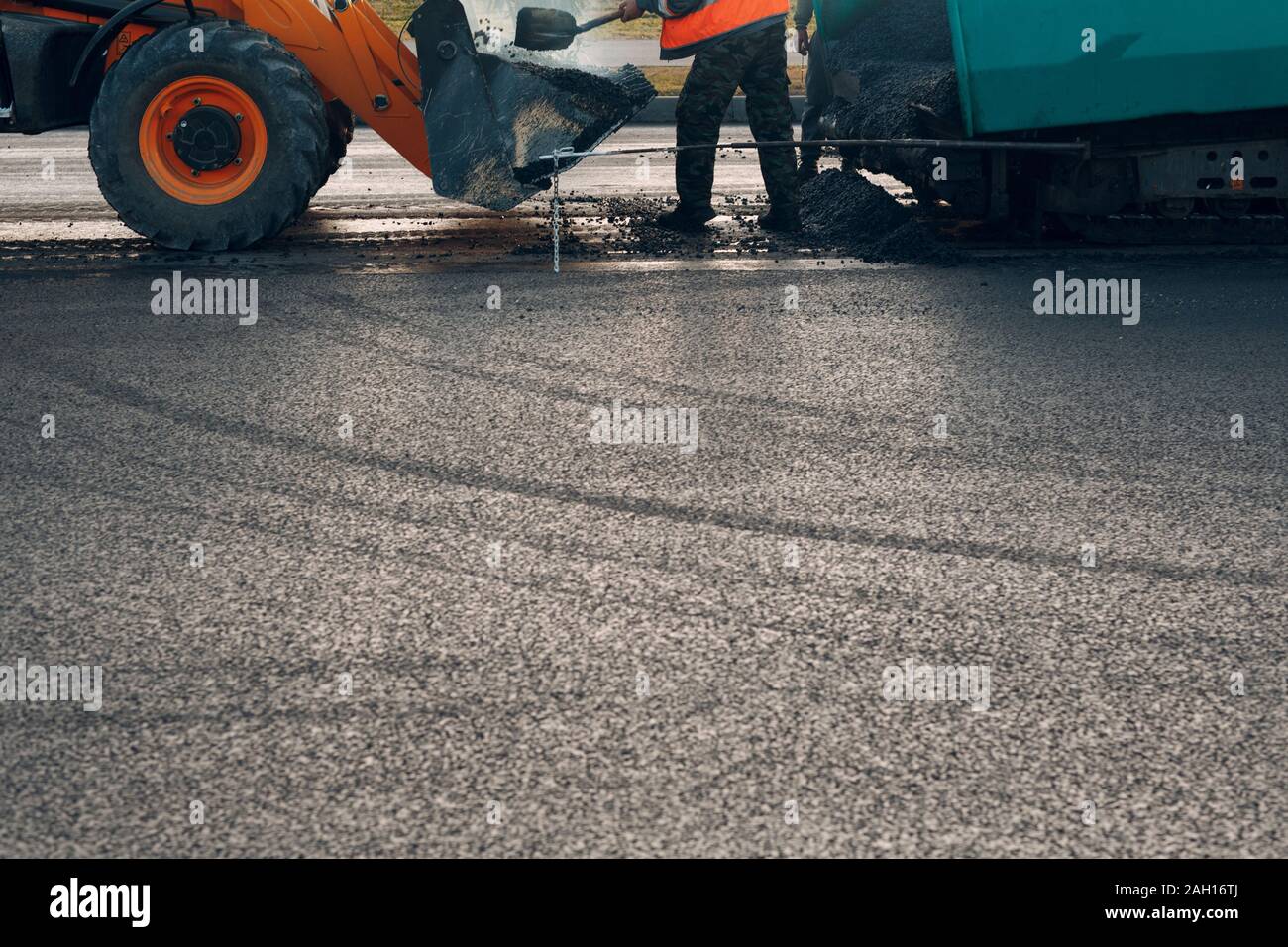 Asphalt paving. Paver man and road roller. New road construction Stock