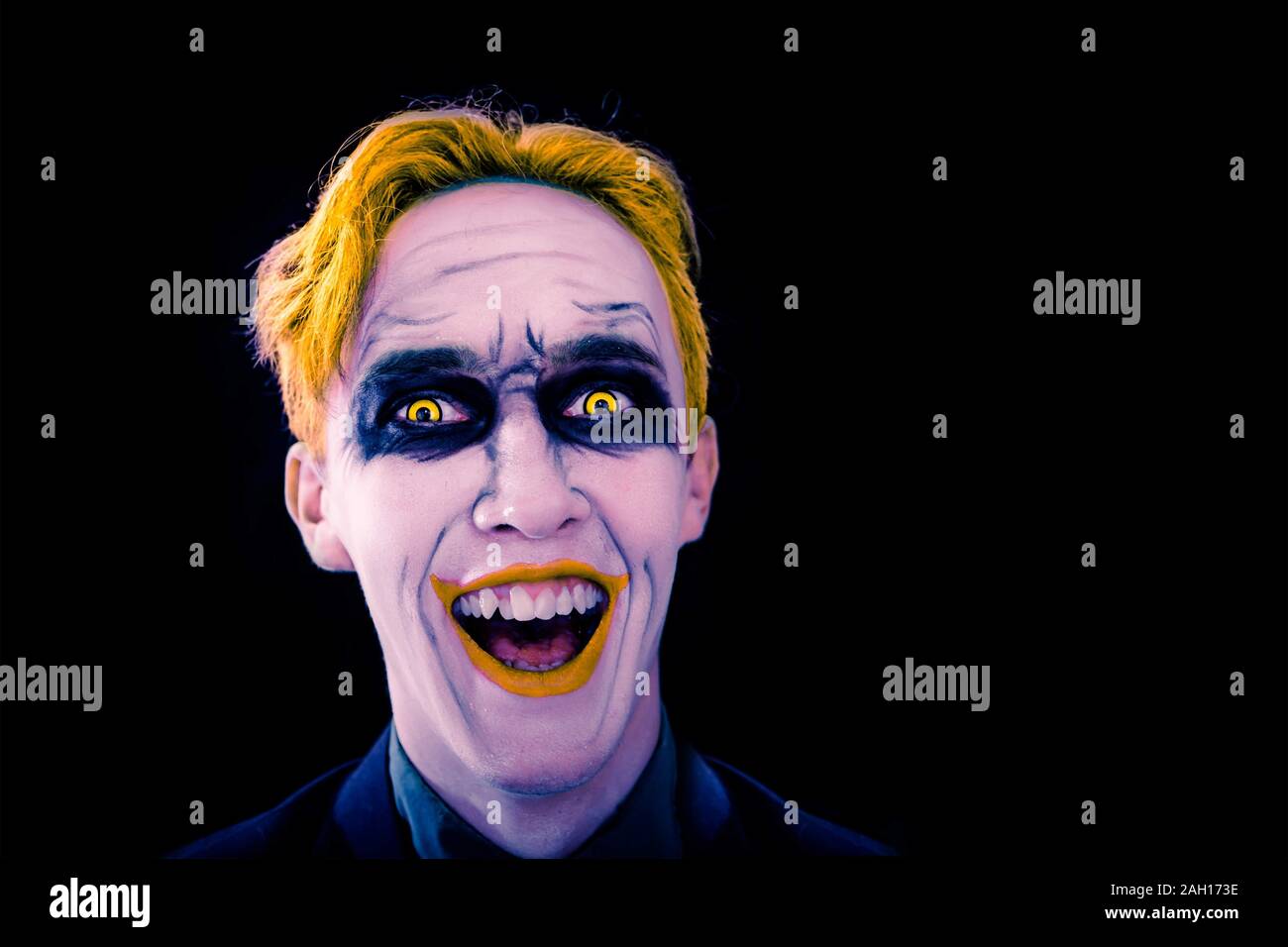 Cosplay joker from the movie 50's. Smiling clown on the black background. Halloween party. Copy space for text. Stock Photo