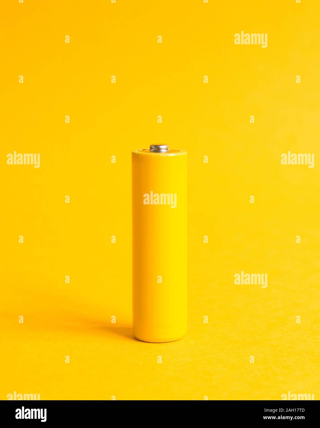Single yellow battery on a yellow pastel background with crop for instagram Stock Photo