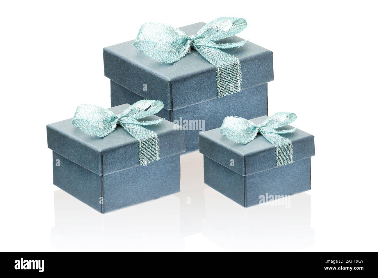 Three gift gray with a greenish tinge boxes isolate on a white background, close-up, reflection. Stock Photo