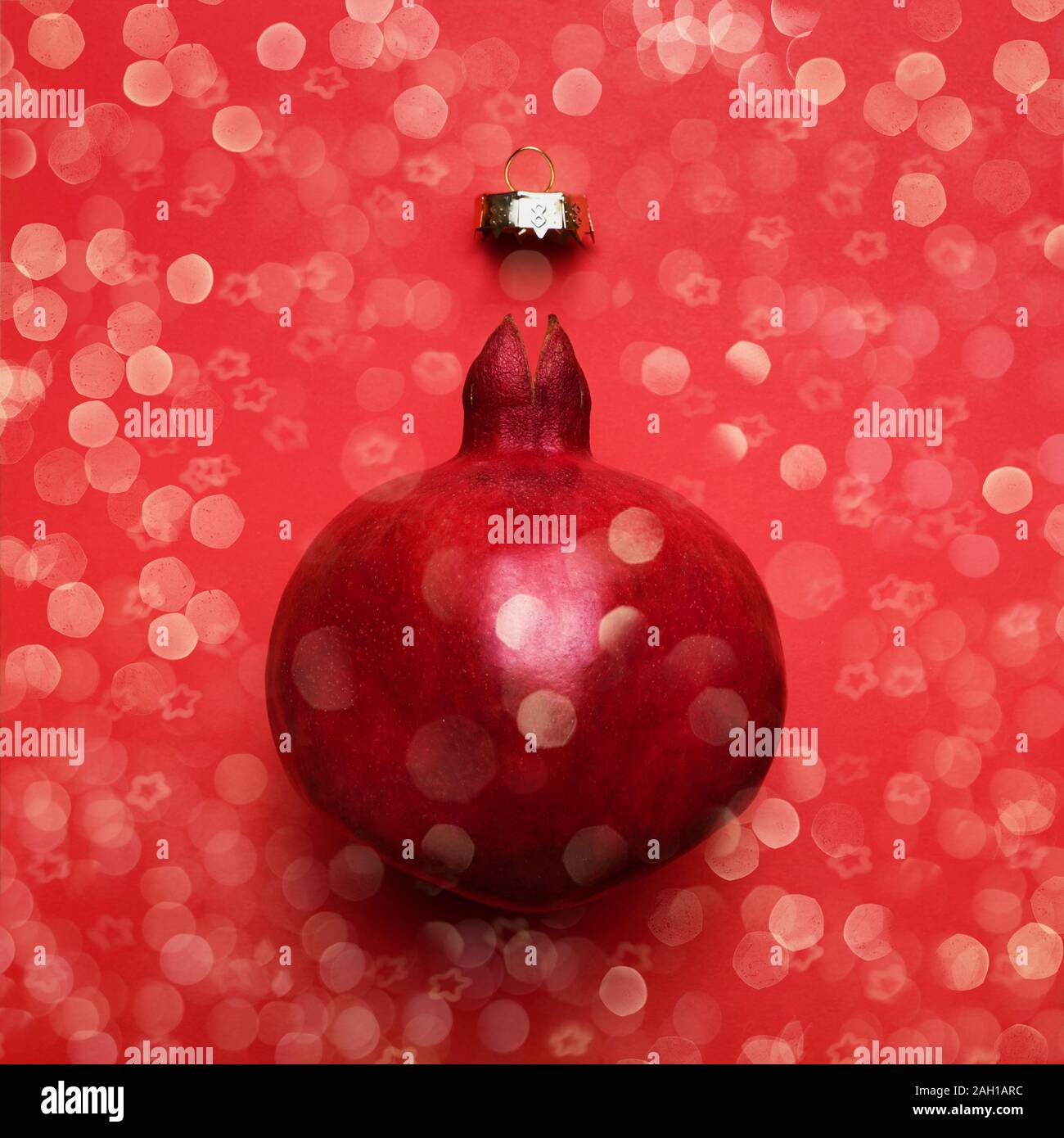 Red Christmas greeting card with pomegranate and bokeh on red background. Copy space for text, top view. New Year celebration concept. Stock Photo