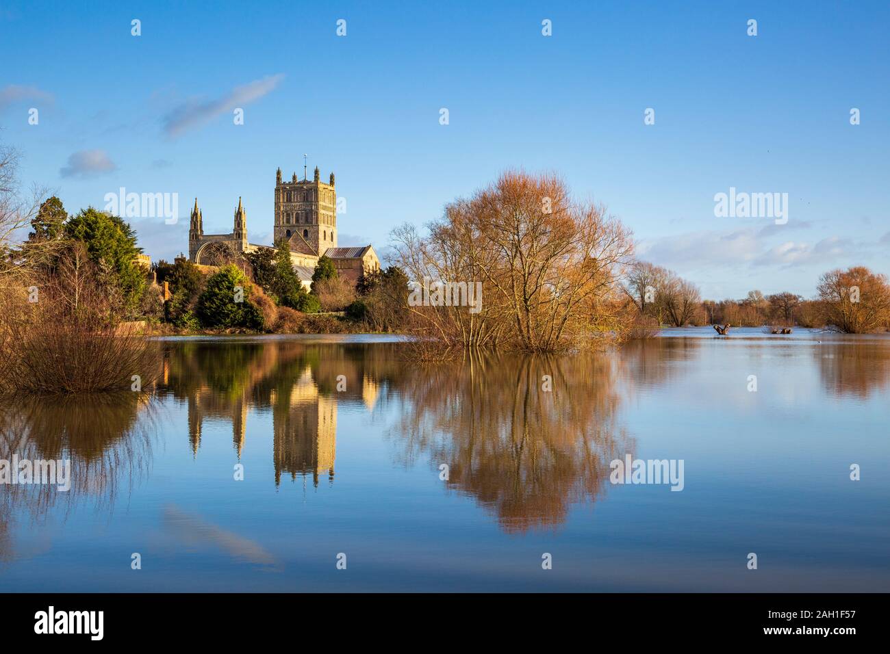 Tewkesbury Abbey across the flooded Swilgate River in winter, England