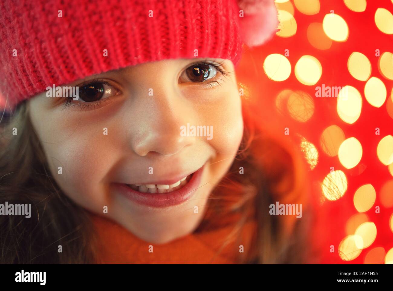 Happy little girl and Christmas lights on background. Happy new year. Stock Photo