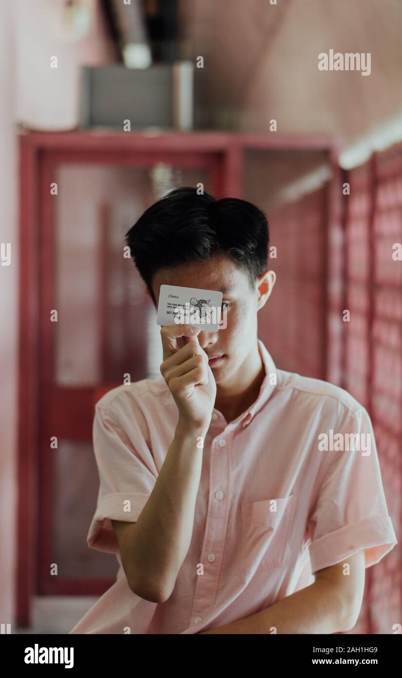 Chance for Freedom: Singaporean Young Man, 'Get Out of Jail Free' Pass, Pink Gates, Uncertainty, Lifestyle, Opportunity, Decision, Liberation, Concept Stock Photo