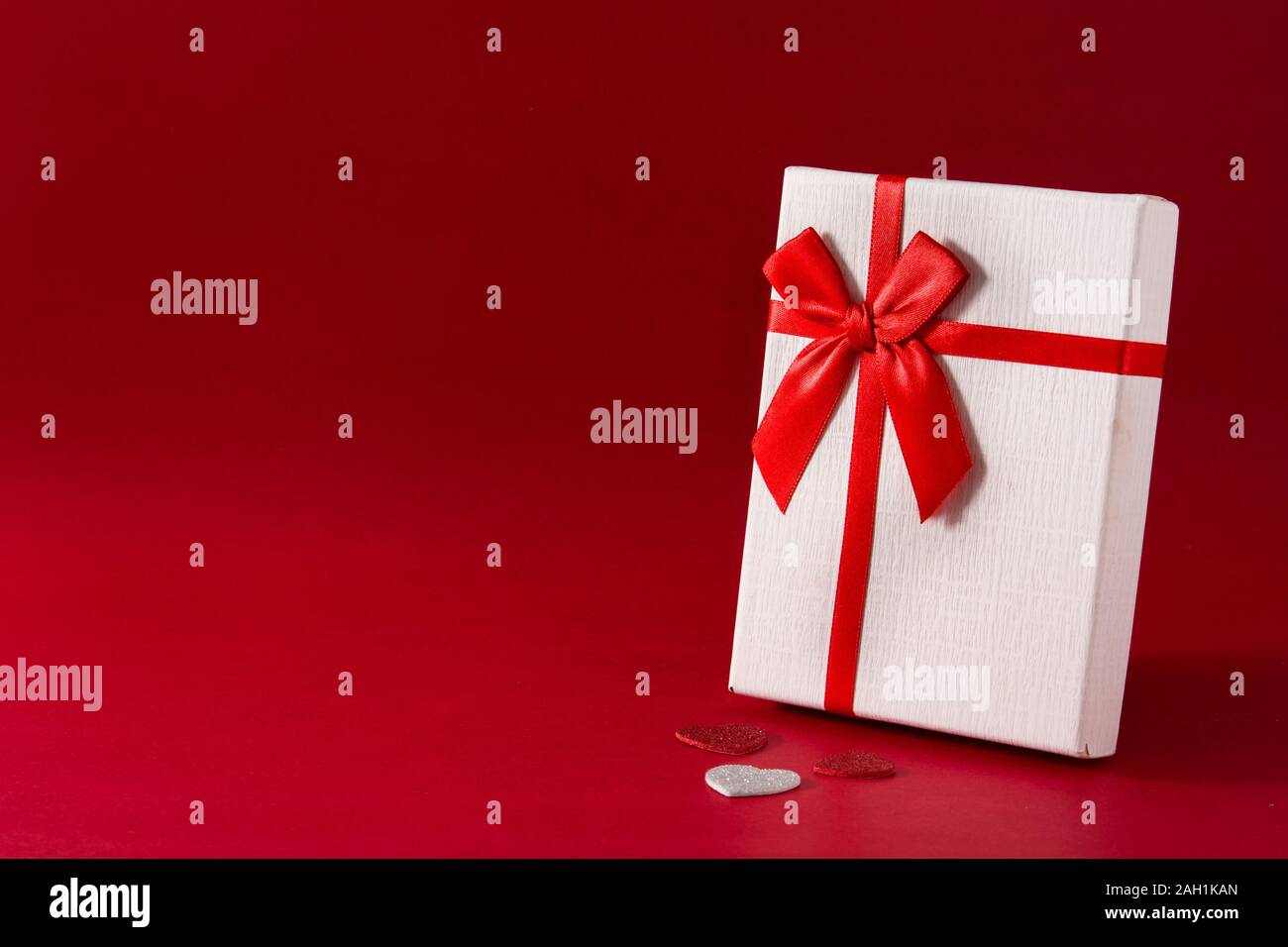 White gift box with red ribbon on red background. Copy space Stock ...