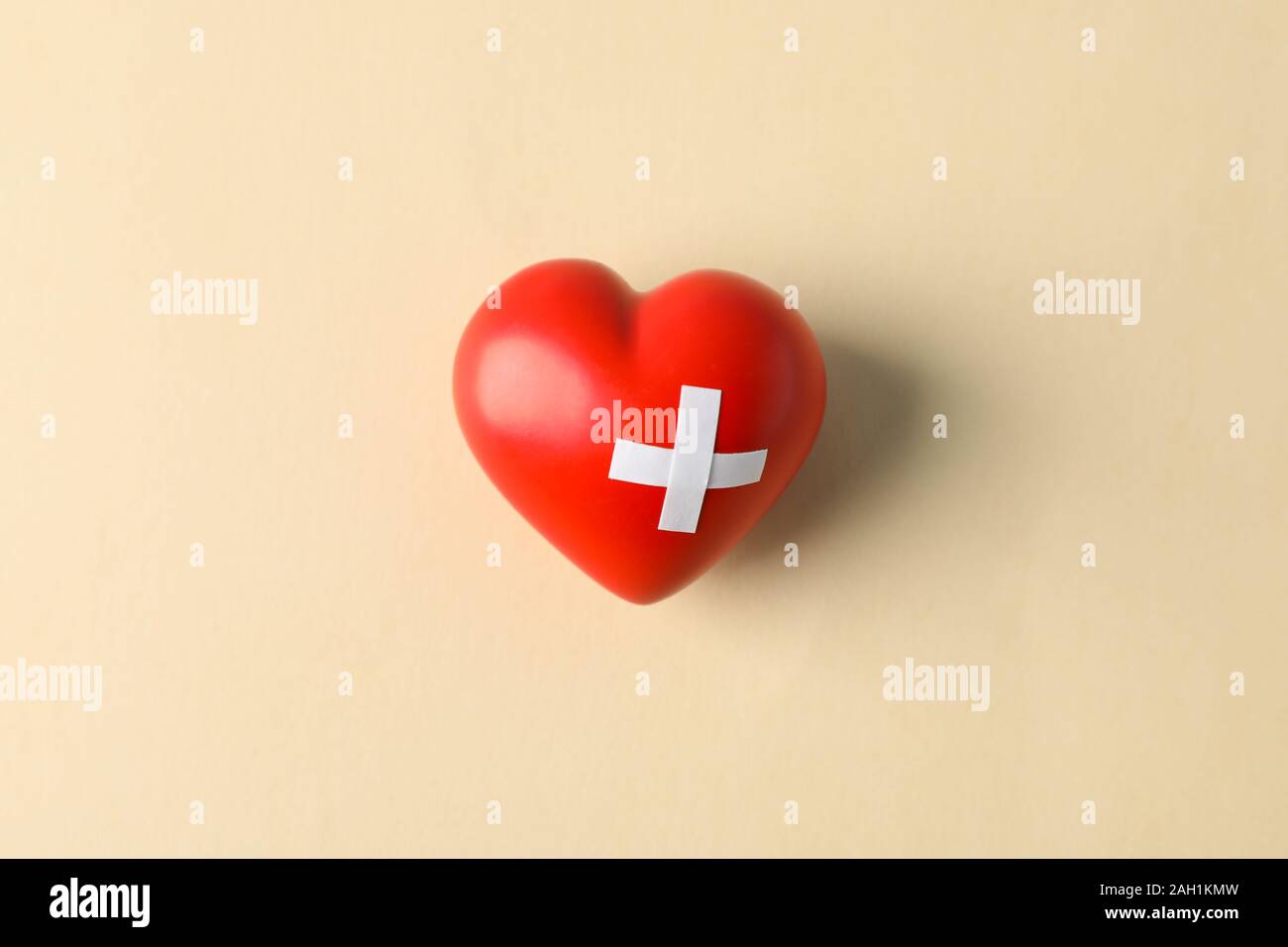 Red heart on beige background, space for text Stock Photo