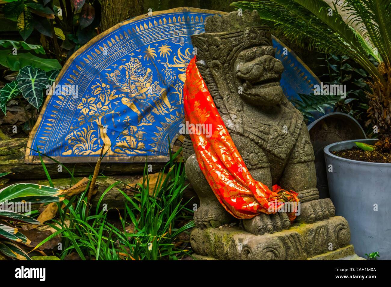 Traditional asian decorations in a a garden, feng shui lion with an fan