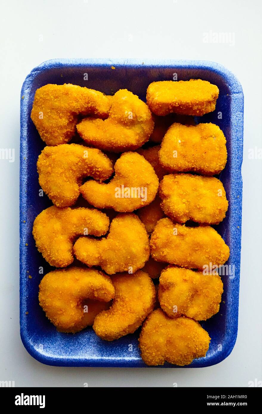 Breaded chicken nuggets in plastic tray on white background Stock Photo Alamy