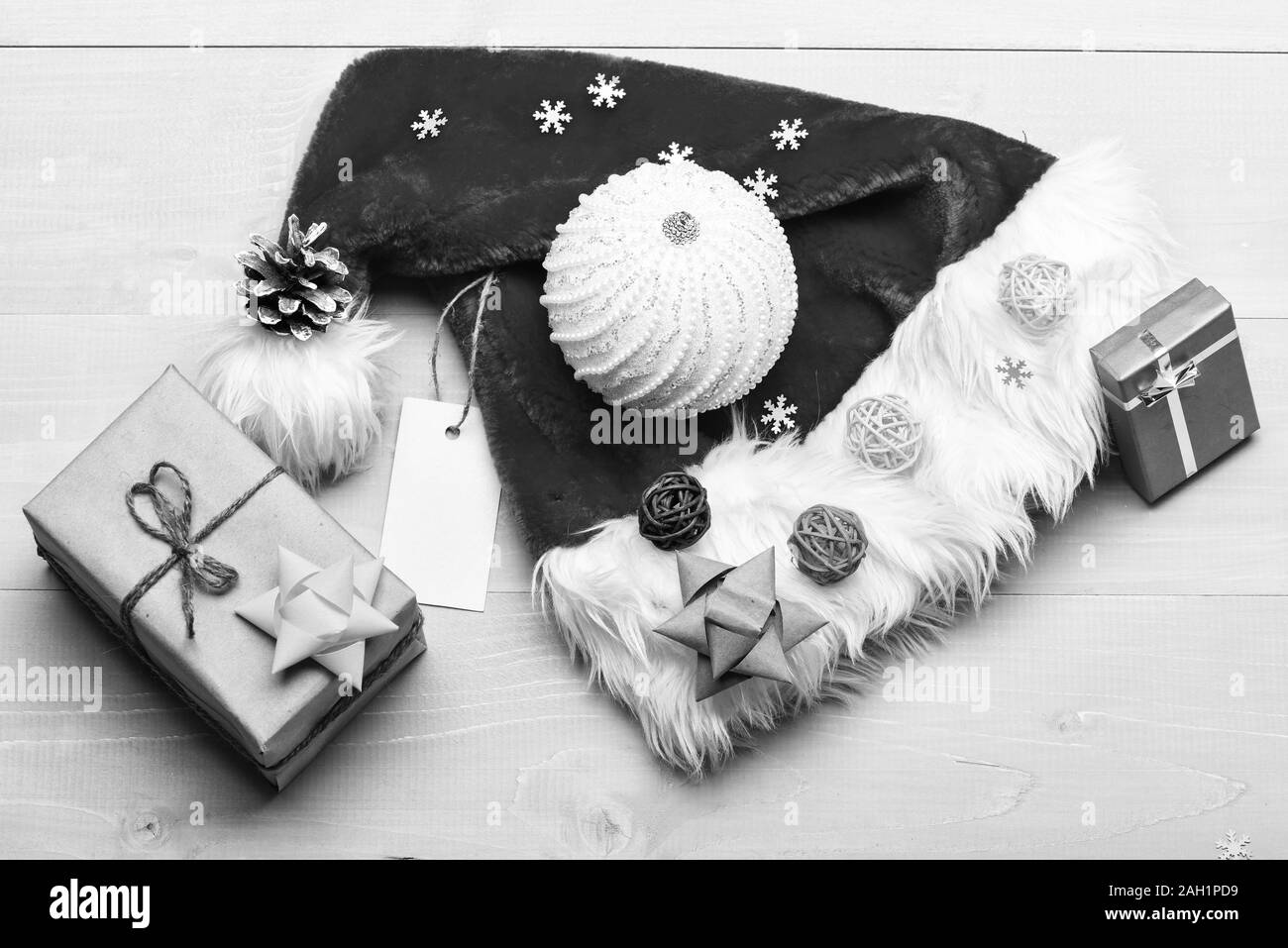 Christmas presents from santa. Santa hat white background top view. Atmosphere is all about details. Winter holidays attributes. New year and christmas decorations. Santa hat and christmas gift box. Stock Photo