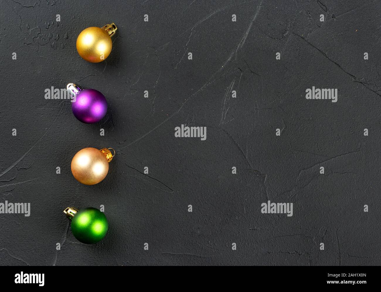 Four colorful Christmas balls on an empty concrete background Stock Photo